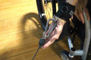 D-ring aid attached to karabiner in gym. Adaptive gym equipment. Suitable for reduced hand function: tetra, quad, cerebral palsy, SCI, spinal cord injury, limb difference, stroke and more.