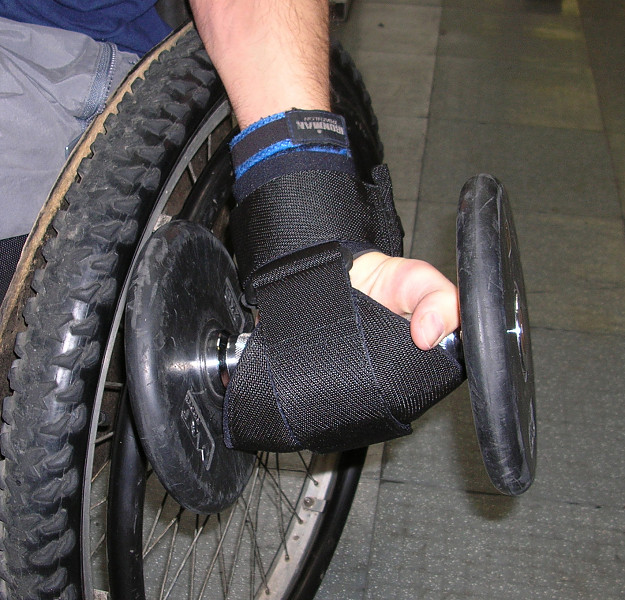 General Purpose gripping aid being used with a free weight by man in wheelchair