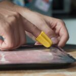 nimble being used to slice through bacon packaging to help with reduced hand function