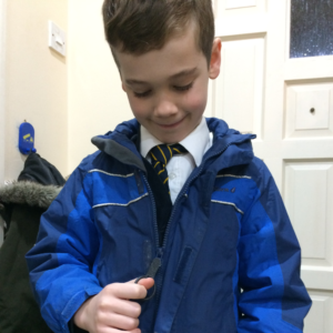Zip grip zip pull on blue child's coat. Suitable for reduced hand function: tetra, quad, cerebral palsy, SCI, spinal cord injury, stroke and more.