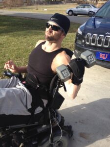 Jerod lifting free weights outside with General Purpose aid. Adaptive gym equipment. Suitable for reduced hand function: tetra, quad, cerebral palsy, SCI, spinal cord injury, limb difference, stroke and more.