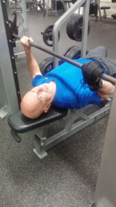 Jose in the gym with the General Purpose aid. Adaptive gym equipment. Suitable for reduced hand function: tetra, quad, cerebral palsy, SCI, spinal cord injury, limb difference, stroke and more.