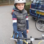 Boy on bike - right hand holding on with Limb difference aid