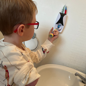 Callum, who has an upper limb limb difference, uses the toothpaste dispenser to clean his teeth independently