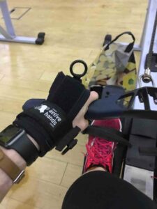 Phillippa using a Limb Difference aid on rowing machine in the gym