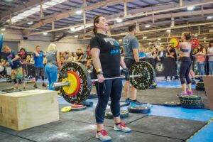 Tina using a limb difference aid to lift a heavy weight.