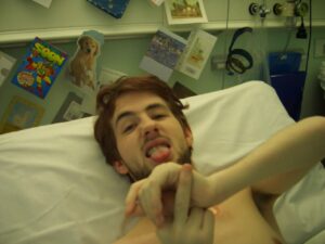 Gareth in hospital bed pulling a funny face