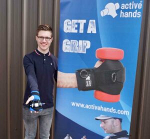 Sam with Active Hands 'Get a Grip' banner, with Small Item aid on his hand