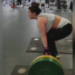 Kaitlin with cerebral palsy weightlifting with the help of her General Purpose gripping aids.