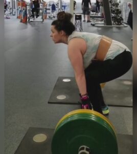 Kaitlin with cerebral palsy weightlifting with the help of her General Purpose gripping aids.