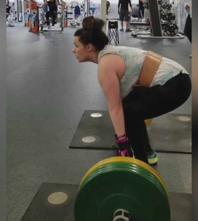 Kaitlin with cerebral palsy weightlifting with the help of her General Purpose gripping aids.