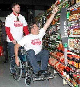 wheelchair user reaching for high-up products in supermarket