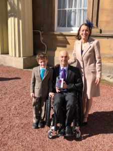 Rob, Jo and their son Jacob outside the palace with the MBE medal