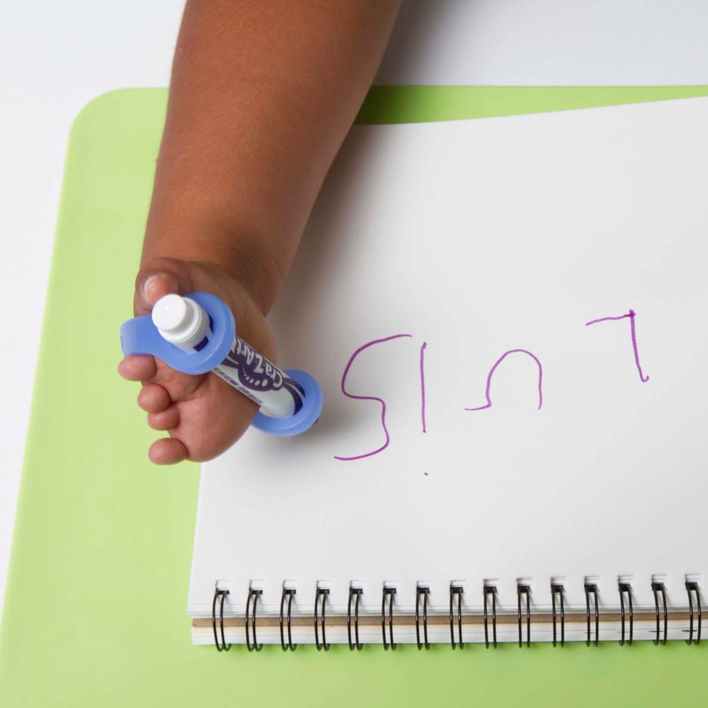 child with limb difference holds pen with easy hold grip