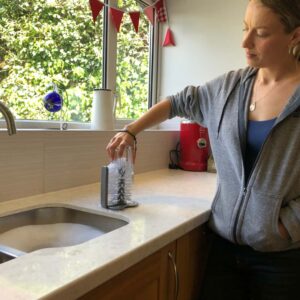 Jo uses the free-standing washing up brush to clean a glass