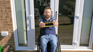 Gareth uses the theraband to do a chest pull