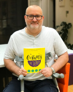 Ian Taverner showing his bright yellow Cookfulness book