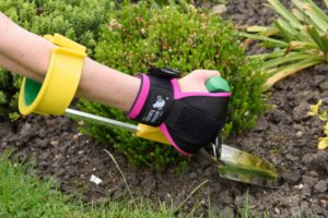 Right angled trowel with arm cuff being used for digging