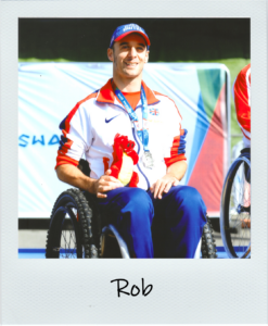 our Director, Rob, in British Paralympic clothing, smiling with his medal