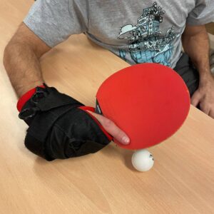 Tennis table bat being held with the angled aid with one finger up the bat