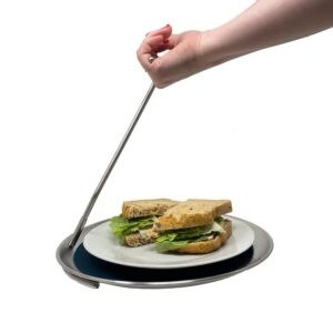 The topple tray with a sandwich on a plate on it being held by a hand.