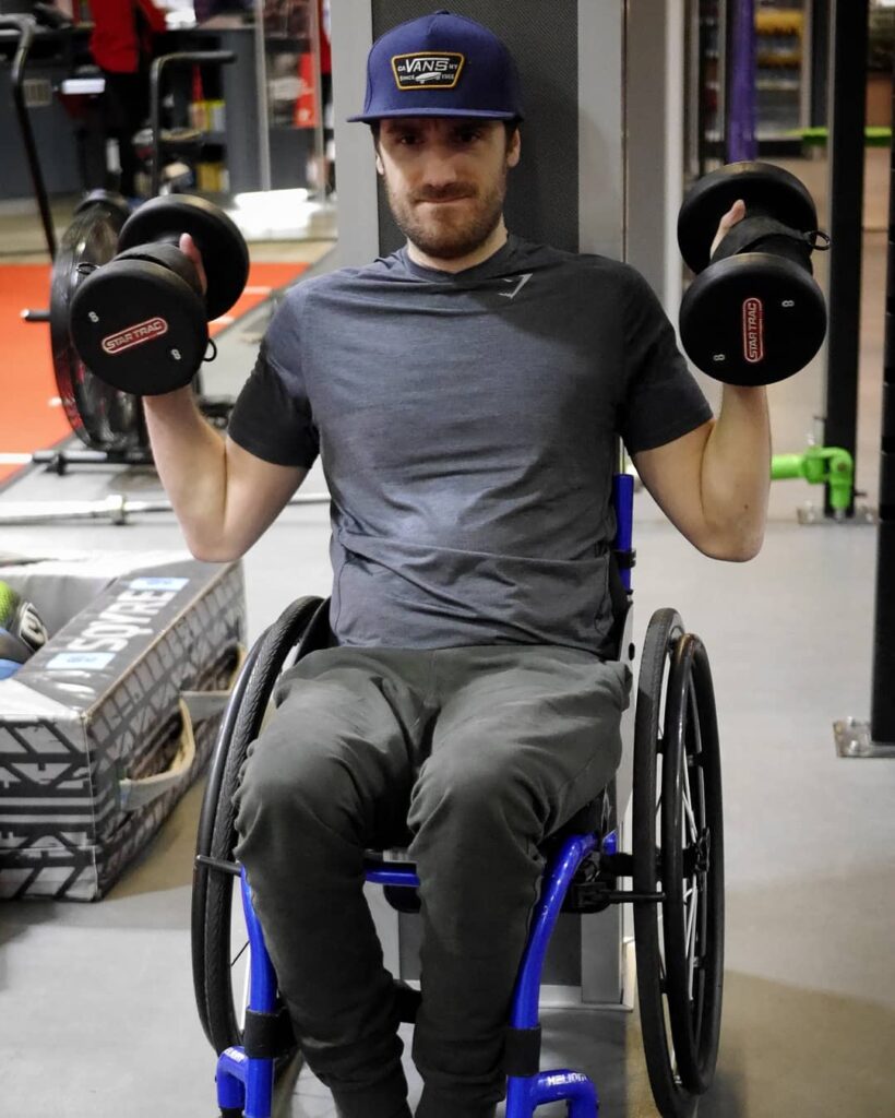 Ben holding 2 free weights using gripping aids
