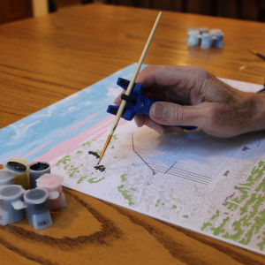 adult using a functional hand to paint