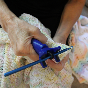 person uses a functional hand to hold a crochet hook