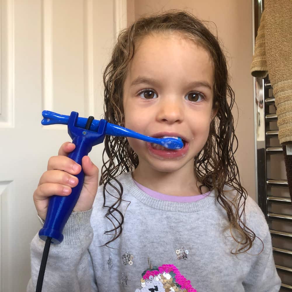 The FUNctionalHand being used to hold a toothbrush to brush a child's teeth