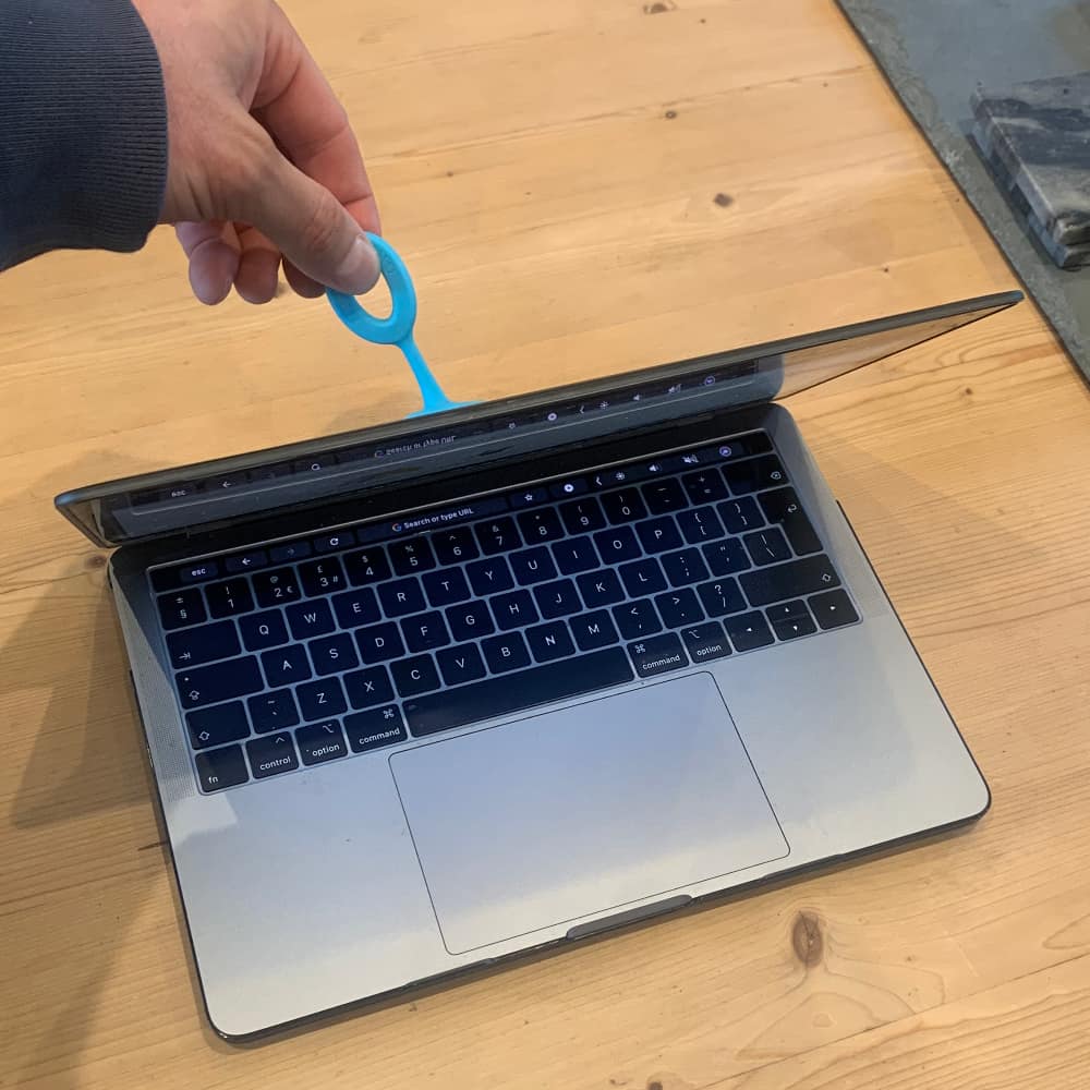 The grip toggle has a suction cup that allows you to open laptops