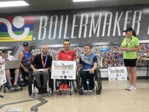 Rob and two fellow wheelchair racers receive their medals and awards for the Triple Crown Series. Rob is in silver position.