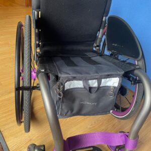 The wheelchair box attaches under your seat using flaps with velcro on them