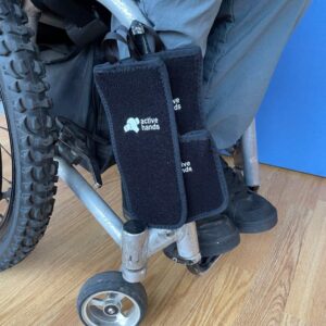 All three HandiPouch sizes stuck to each other on the leg of Rob's wheelchair.