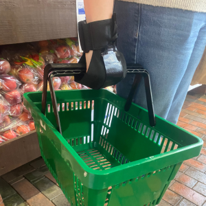 Lite aid gripping aid on hand holding green shopping basket