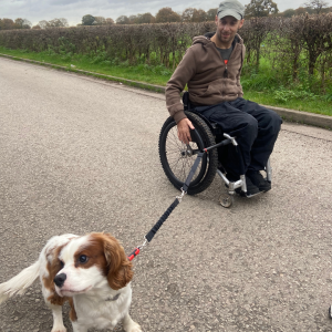 Rob using the wheelchair dog lead with a cute King Charles Spaniel