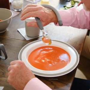 sloped one-handed plate in use with long bendable cutlery