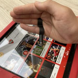 Image shows a child's hand with a wearable stylus, using the stylus to operate a tablet screen.