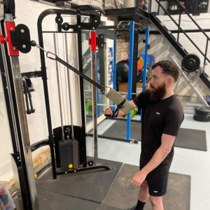 Harry who is an athlete with a limb difference uses the Gecko band on a cable and pulley machine
