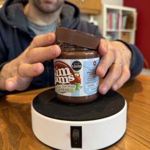 image shows a jar of chocolate spread on the hold fast platform. Rob;s hands are shown taking the lid off